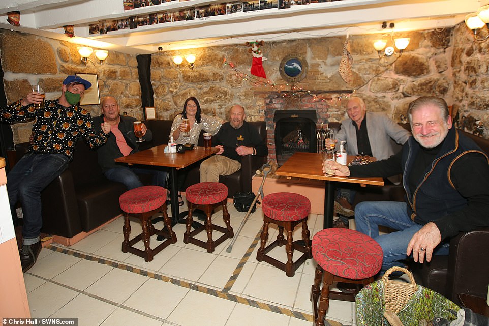 ISLES OF SCILLY: In stark contrast to the rest of the UK, locals on the Isles of Scilly were pictured enjoying a New Year's Eve drink in the only three pubs in England which are open tonight