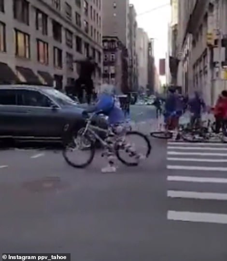 Pictured: A still from the video of the incident which saw a group of teenagers attacking the SUV in Manhattan. Shown from two angles, one of the teenagers is seen jumping on the windshield of the car, smashing it in the centre with both feet