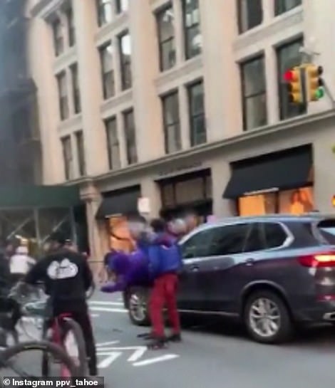 Another still taken from videos of the attack on the SUV. In this picture, one of the teens is seen using his bicycle to hit the front of the vehicle. The same moment is shown from two angles