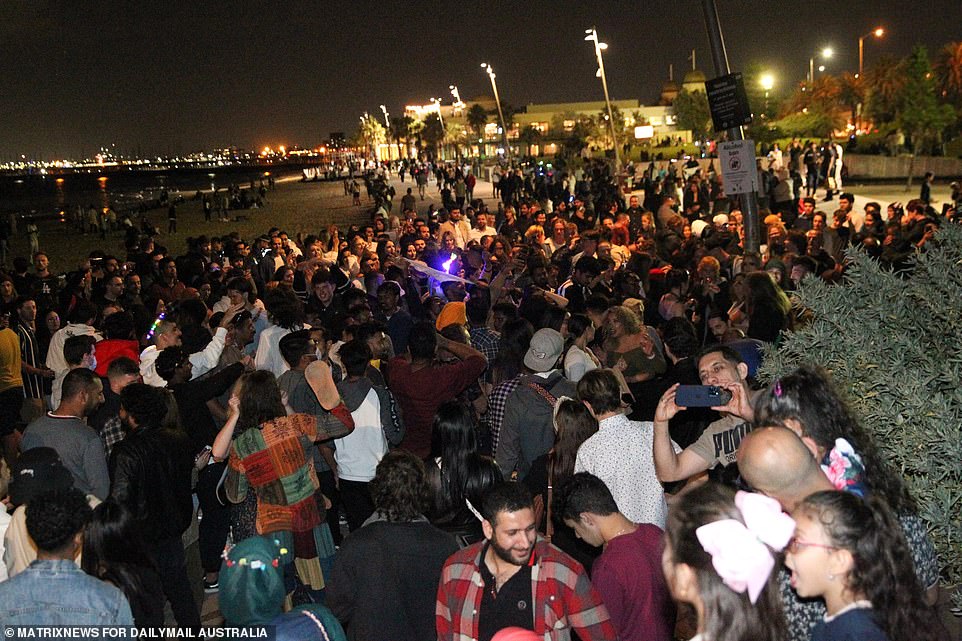 Large crowds are seen dancing at St Kilda Beach as Melbournians bring in the New Year in St Kilda after spending months in lockdown