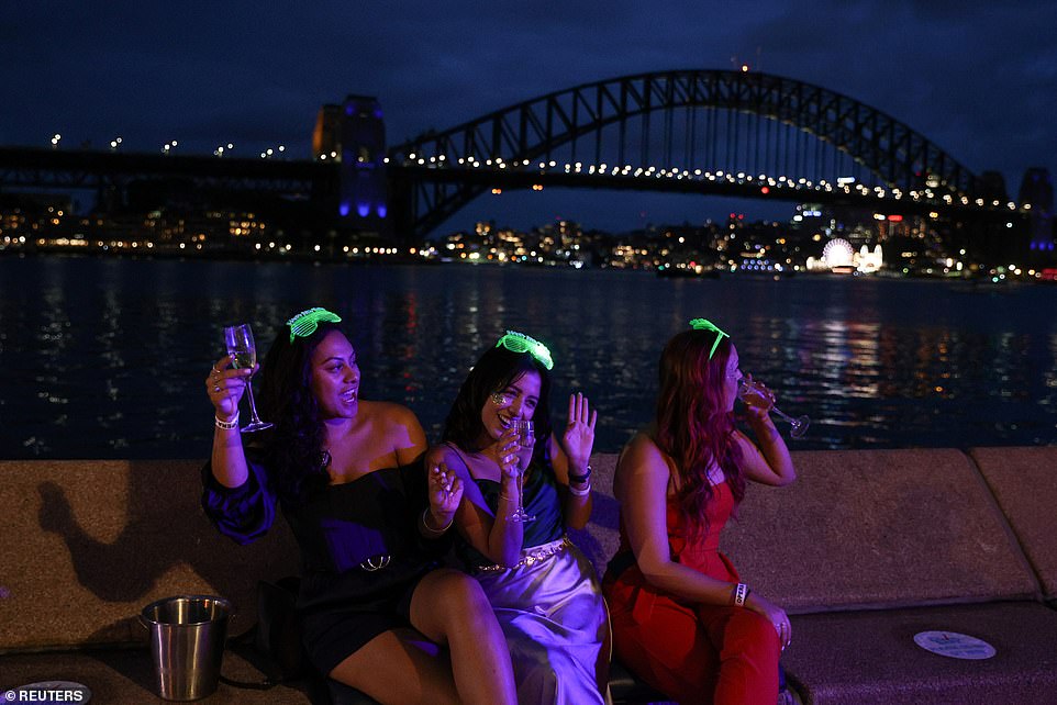 Friends with prime viewing of the Sydney Harbour Bridge prepare to farewell 2020 and watch the seven minute fireworks display
