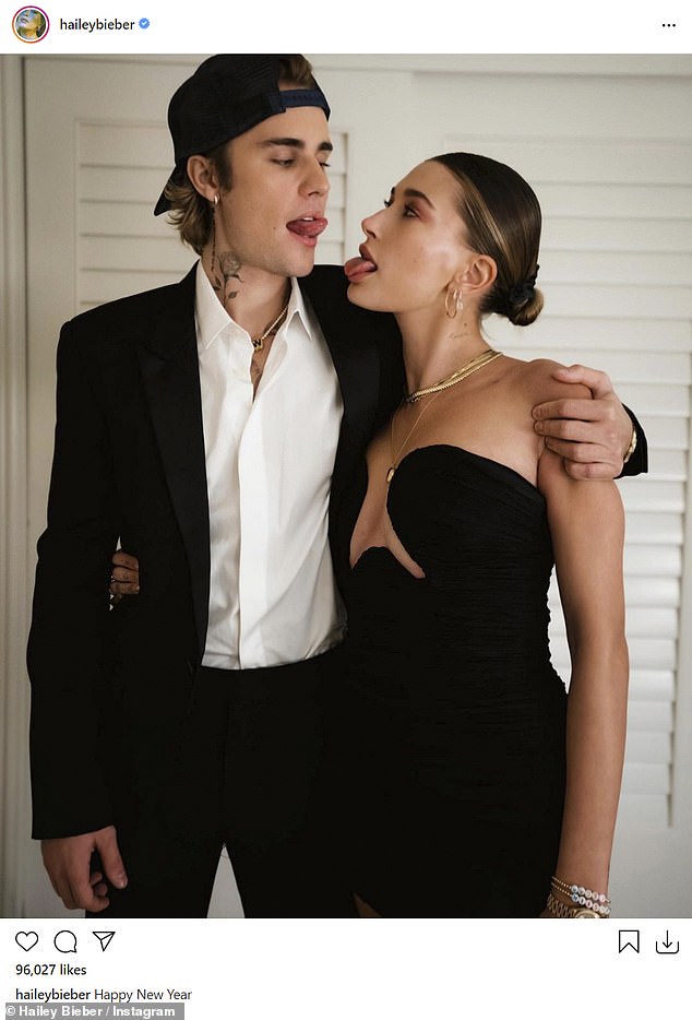 So in love: The model went on to share a photo of herself with her hitmaker hubby, who wore a black suit with open-neck white shirt and a backwards facing black baseball cap
