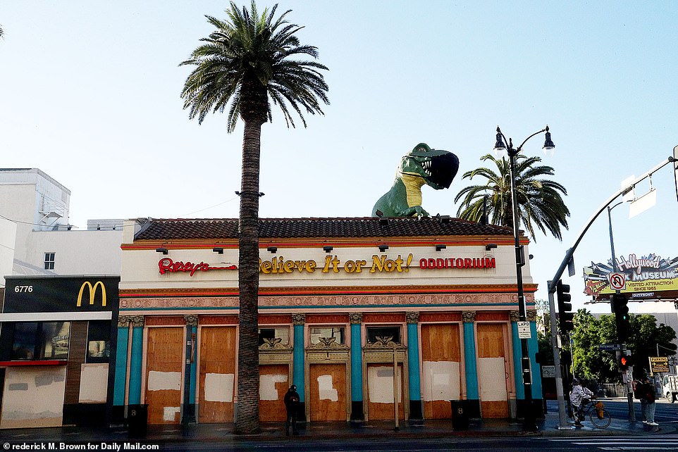The dinosaur atop of Ripley's Odditorium now wears a huge mask as it looks down upon the empty street
