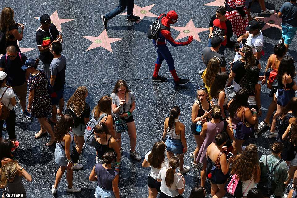 Will it ever be this way again? Tourists are propositioned for pictures by people dressed as characters from movies as they walk past the stars along Hollywood Boulevard in August 2017