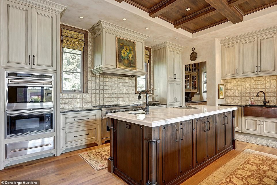 The open plan kitchen is complete with marble counter tops, a butler's pantry and two islands