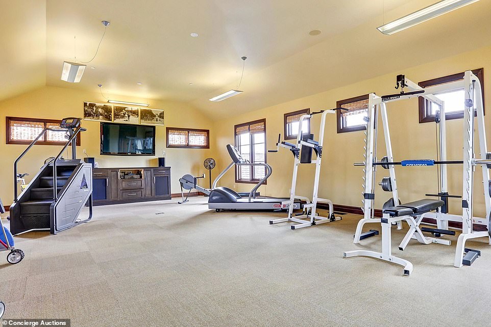 Pictured is the property's huge home gym, complete with exercise equipment, surround sound and a flatscreen TV