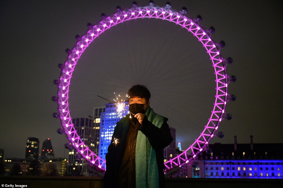 LONDON: A man holds a sparkler in front of the London Eye, in what would normally be a ticket-only area filled to capacity waiting for the annual fireworks display