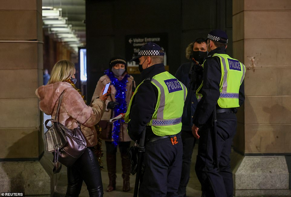 LONDON: Two police officers speak to a group of people this evening as Tier 4 restrictions mean New Year's Eve celebrations must be held in people's own homes rather than out partying