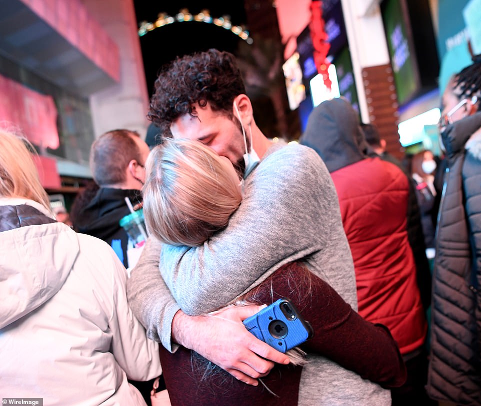 A young couple kiss with their masks pulled down during a New Year's Eve celebration on the Las Vegas Strip