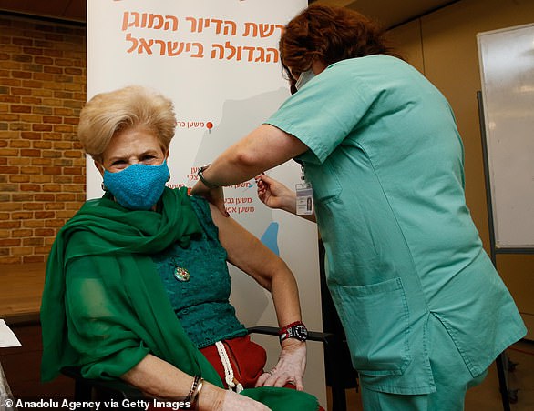 A medical worker administers the Pfizer vaccine in a care home in Tel Aviv on New Year's Eve