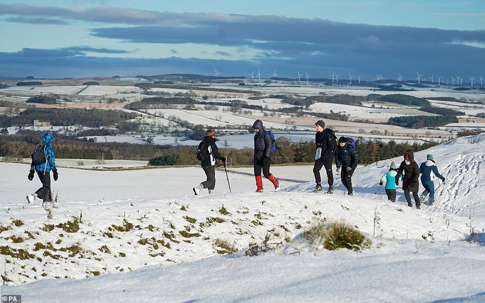 Hikers at Limestone Corner walk along a snow-covered Hadrian's Wall near Hexham, Northumberland, this morning