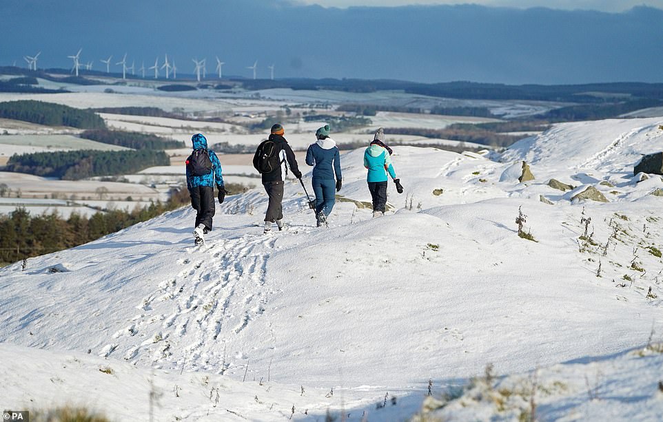 Hikers at Limestone Corner leave footprints in the snow at Hadrian's Wall near Hexham, Northumberland