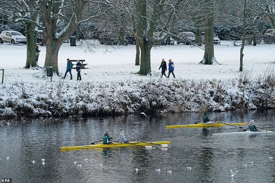Rowers on the River Tyne at Hexham, Northumberland, keep warm in hats and jackets during their training