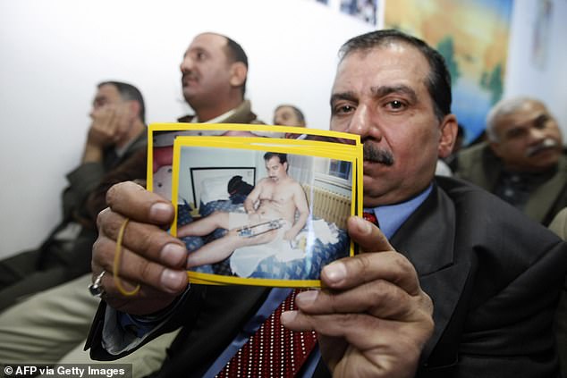 An Iraqi victim of the shooting incident holds up a picture of himself, during a meeting with US Federal Prosecutors to discuss the case against the security firm Blackwater