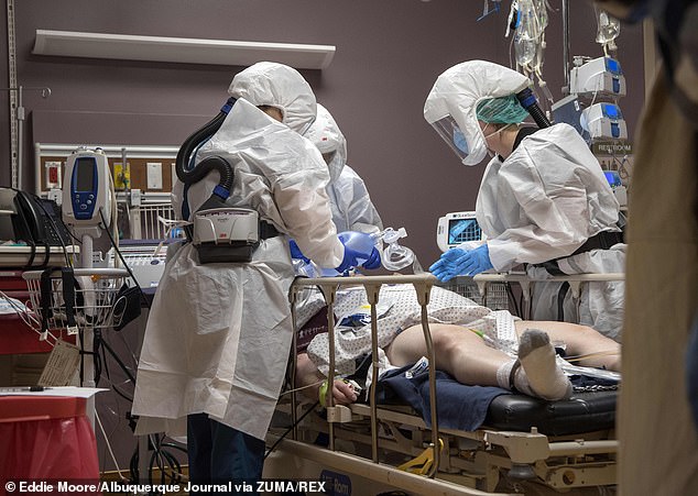 Registered nurses Mandy Cordova (left) and Mikayla Salazar (right) help Dr. James Gonzales put a breathing tube for a respirator into a COVID-19 patient at Guadalupe County Hospital in Santa Rosa, New Mexico, on December 11