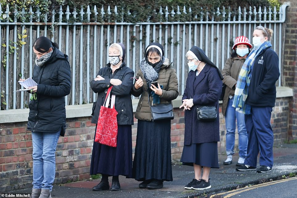 The rollout of the Pfizer/BioNTech vaccine began
 almost a month ago with more than a million people having already received their first coronavirus jab. Pictured: People queue to receive a Covid-19 vaccine at Sussex House in Brighton today