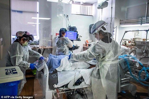 Overall California has recorded more than 2.3million COVID-19 cases and more than 26,000 virus-related deaths since the start of the pandemic. A view of nurses tending to a COVID-19 patient at Providence Cedars-Sinai Tarzana Medical Center in Tarzana, California on December 18 above