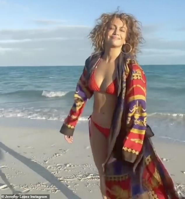Beach babe on the loose: In the new clip, Jennifer is smiling with her chin up as she walks then dances on the shore in Miami
