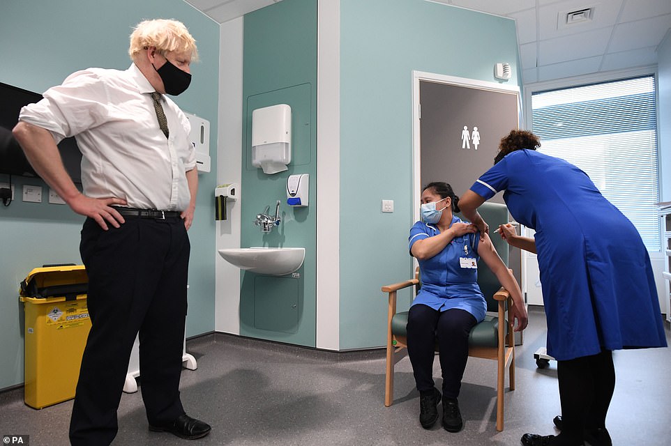 Prime Minister Boris Johnson watches as Jennifer Dumasi is injected with Oxford/AstraZeneca Covid-19 vaccine during a visit to Chase Farm Hospital in north London earlier today