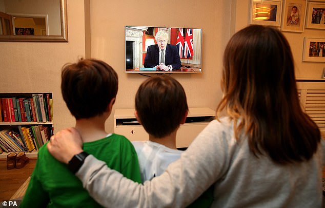 Vulnerable people will once more be required to 'shield' by remaining indoors until they are vaccinated Johnson said. Pictured: A family in Cheshire watches Johnson's announcement on Monday night