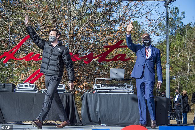 Democratic Senate hopefuls Jon Ossoff (left) and Rev. Raphael Warnock wave to the crowd at an Atlanta rally Monday, headlined by President-elect Joe Biden