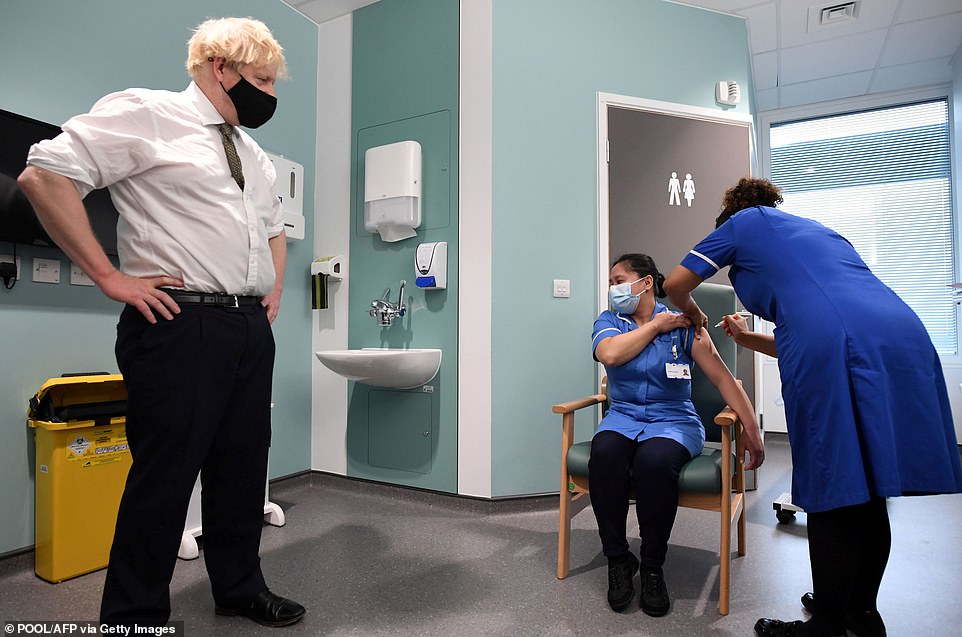 Britain's Prime Minister Boris Johnson watches as Jennifer Dumasi receives a dose of the AstraZeneca/Oxford Covid-19 vaccine during a visit to Chase Farm Hospital in north London