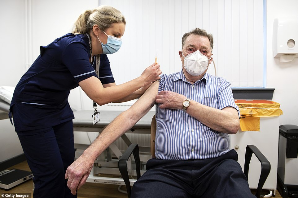 Advanced nurse practitioner Justine Williams (left) prepares to administer a dose of the AstraZeneca/Oxford Covid-19 vaccine to 82-year-old James Shaw, the first person in Scotland to receive the vaccination