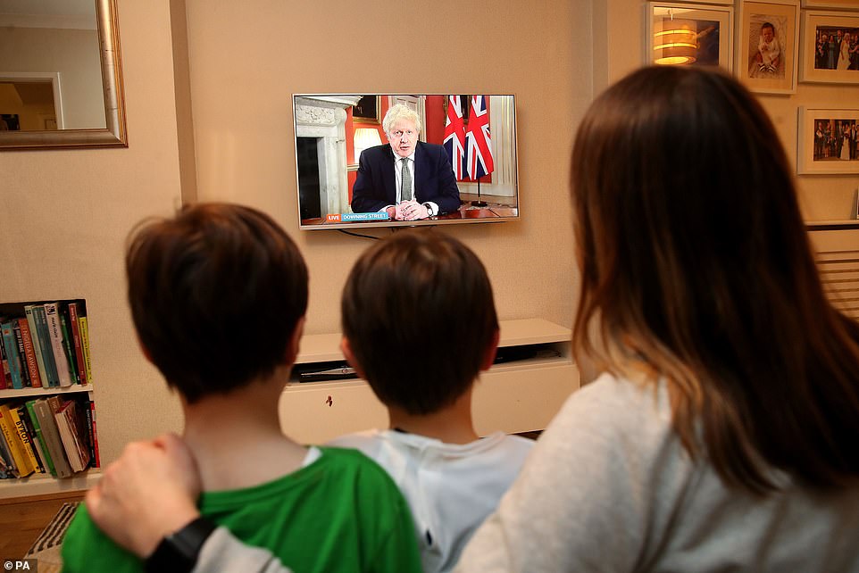 A family in Knutsford, Cheshire, watch Prime Minister Boris Johnson making a televised address to the nation from 10 Downing Street as he shut all schools until February 22