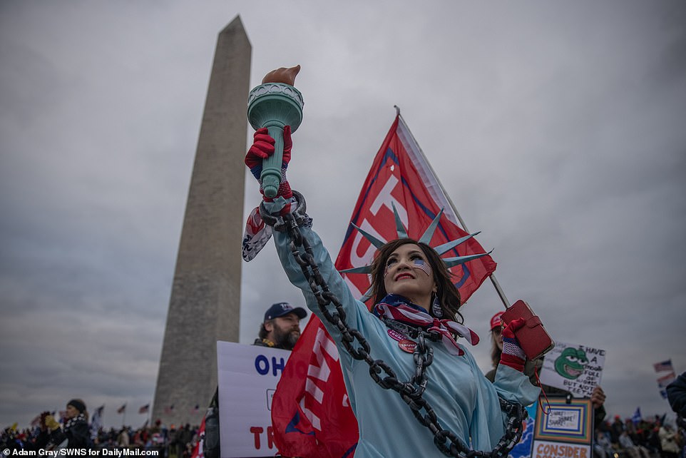 A Trump supporter dressed as the Statue of Liberty while chained in shackles is seen above near the Washington Monument on Wednesday