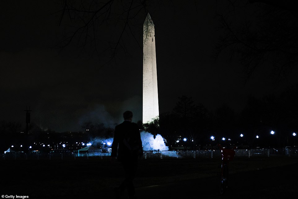 A man is seen standing in front of the Washington Monument as Trump supporters protested