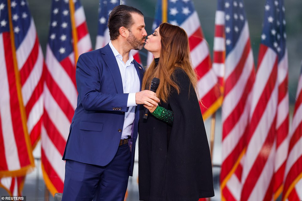 Donald Trump Jr (left), the president's eldest son, kisses his girlfriend, Kimberly Guilfoyle (right), before addressing the rally on Wednesday