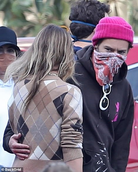 Trademark style: Although the former One Direction star added a touch of his trademark cool style with a pink beanie hat, white sunglasses and patterned face mask which also acted as a scarf