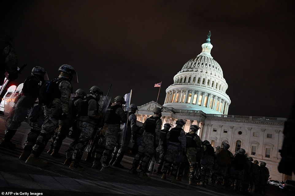 National Guard members line up on the Capitol grounds as protesters continue occupying the area after curfew