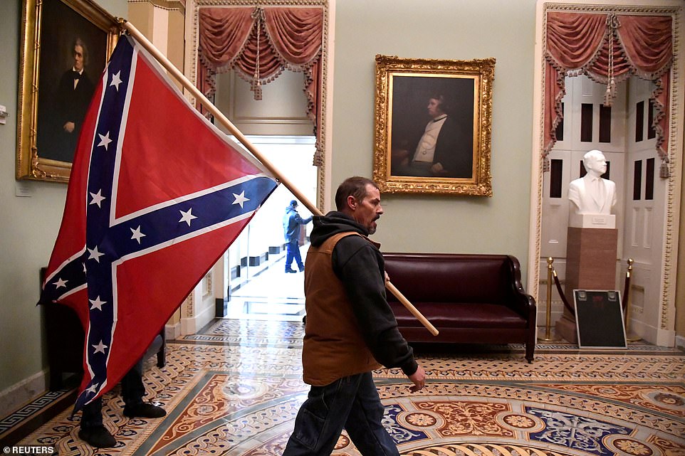 A supporter of President Donald Trump carries a Confederate battle flag on the second floor of the U.S. Capitol near the entrance to the Senate after breaching security defenses, in Washington, U.S., January 6, 2021