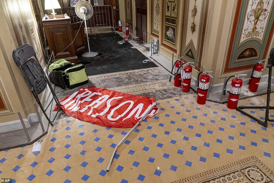 A banner saying, 'Treason,' lies on the ground next to the dust strewn floor and fire extinguishers which appear to have been used