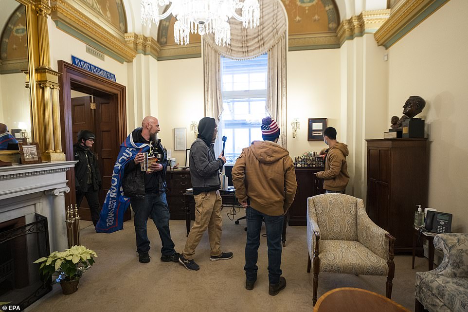 Supporters of US President Donald J. Trump stand inside the office of US House Speaker Nancy Pelosi, after supporters of US President Donald J. Trump breached the US Capitol security in Washington