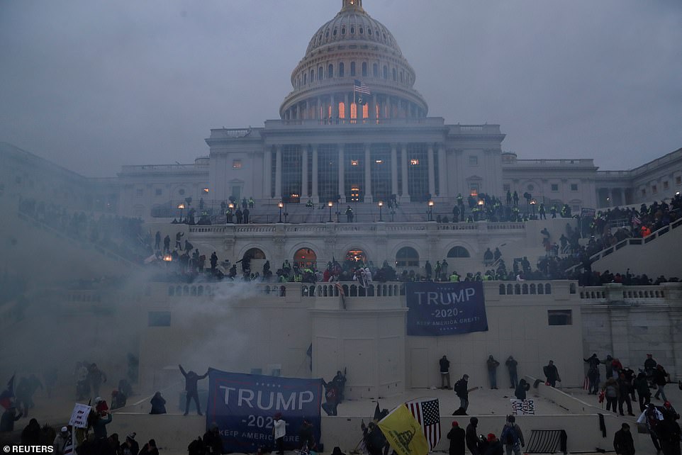 Police officers stand guard as supporters of President Donald Trump gather in front of the US Capitol Building in Washington DC on January 6, 2021