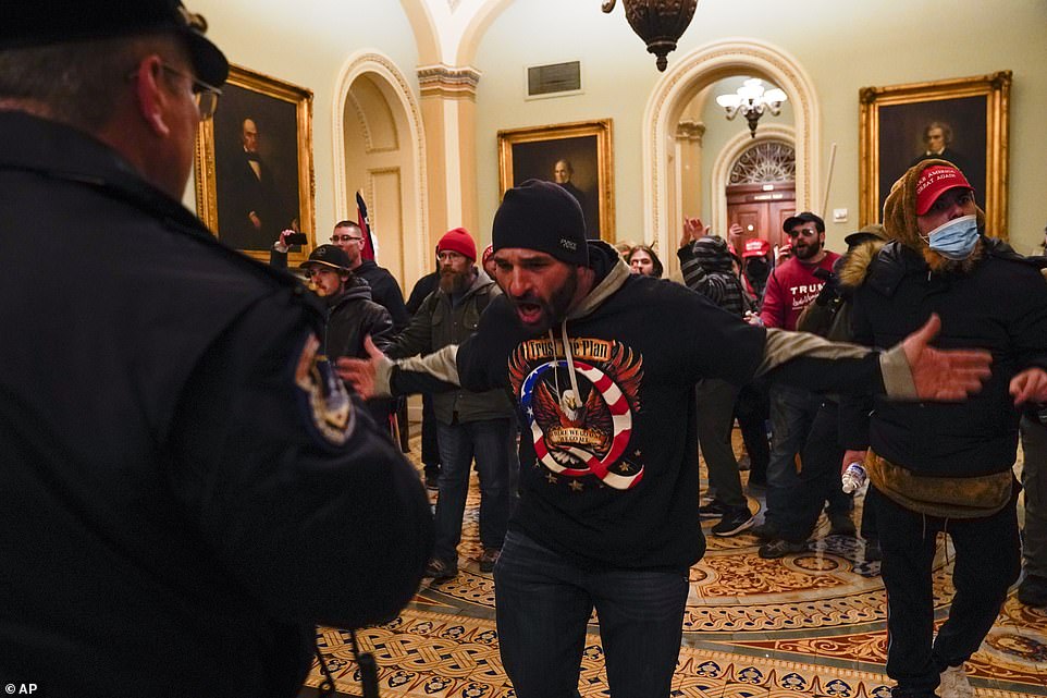 Protesters gesture to U.S. Capitol Police in the hallway outside of the Senate chamber at the Capitol in Washington, DC