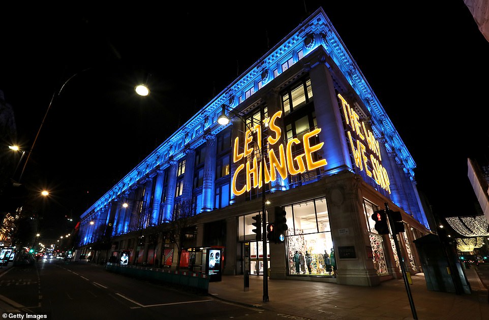 A Selfridges department store on Oxford Street in London is lit up in blue and is emblazoned with the words 'let's change'
