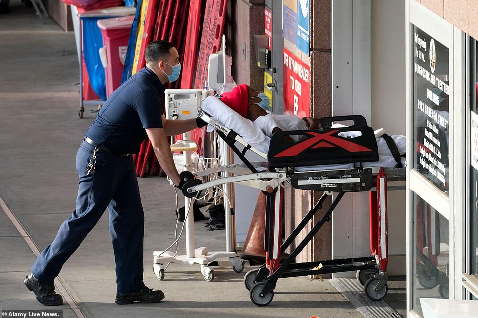 Pictured, a patient is transported to Los Angeles County USC Medical Center. A record 8,000 county residents are currently hospitalized with Covid. Around one in 12 have already been infected, and one in five of those tested recently are positive