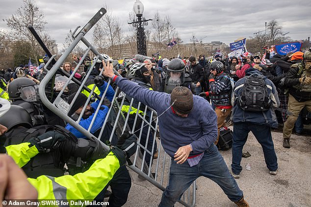 Police spray tear gas at a protester who picked up a police barricade in an effort to get closer to the Capitol