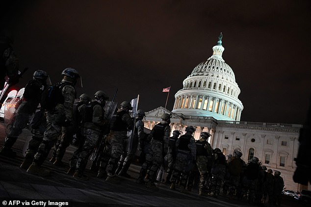 National Guard members line up on the Capitol grounds as protesters continue occupying the area after curfew