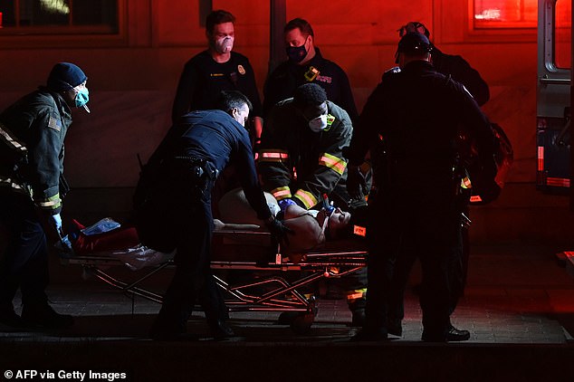 A woman is pushed into an ambulance near the Capitol on Wednesday evening