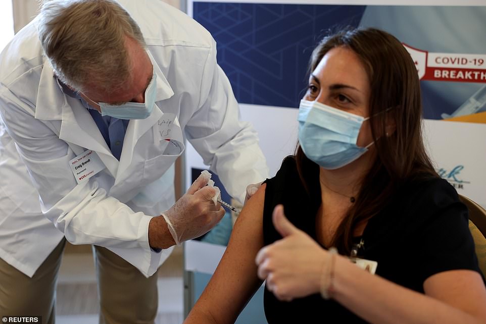 Meanwhile, New York has been very rigid, only giving out vaccines to frontline workers and nursing home residents and staff. Pictured: A staff member at Hamilton Park Nursing and Rehabilitationreceives the Pfizer-BioNTech coronavirus vaccine from Walgreens Pharmacist Craig Brandt in Brooklyn, New York, Janaury 4
