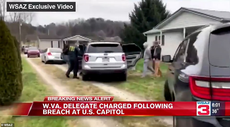 West Virginia delegate Derrick Evans is pictured being arrested at his home in West Virginia Friday. He's facing two federal charges in connection with Wednesday's Capitol riot