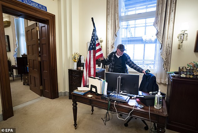 Barnett is pictured inside Pelosi's office on Wednesday, having stormed into the Capitol