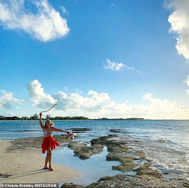 Shore is pretty: She walked along a beach in the Caribbean where she has been on vacation since the new year