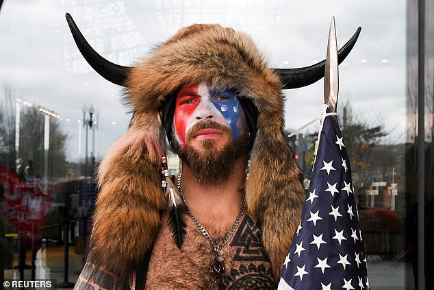 Chansley poses with his face painted in the colors of the U.S. flag as supporters of U.S. President Donald Trump gather in Washington before the protest