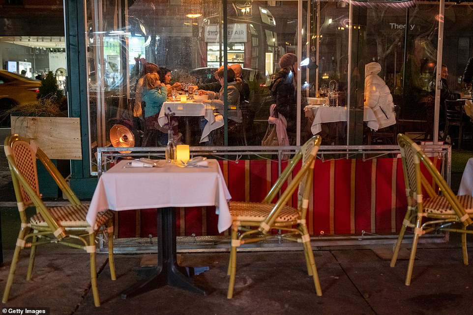 The restaurant industry has struggled immensely amid the pandemic with restrictions on indoor and outdoor dining. Customer's dine in an enclosed outdoor dining tent while tables and chairs on the street remain vacant on December 30 in New York City