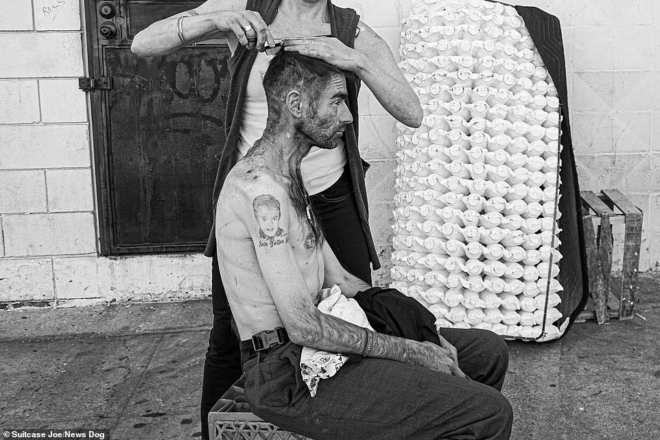 A Skid Row resident gets a haircut from a fellow resident on the sidewalk on Skid Row in Los Angeles